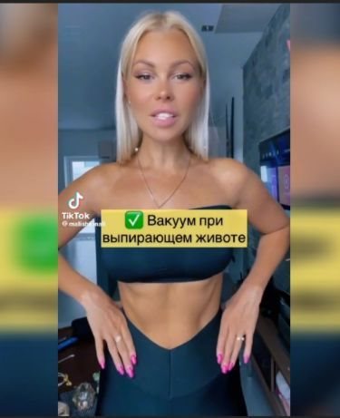 Женщина на берегу реки делает вакуум живота