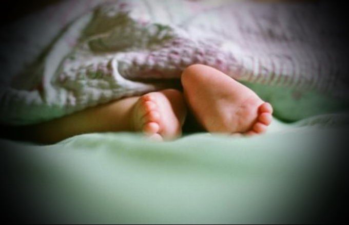 Уложила 2 месячную дочку спать. Детские ножки из под одеяла. Детские ножки в кроватке. Малыш выглядывает из под одеяла. Детские ноги под одеялом.